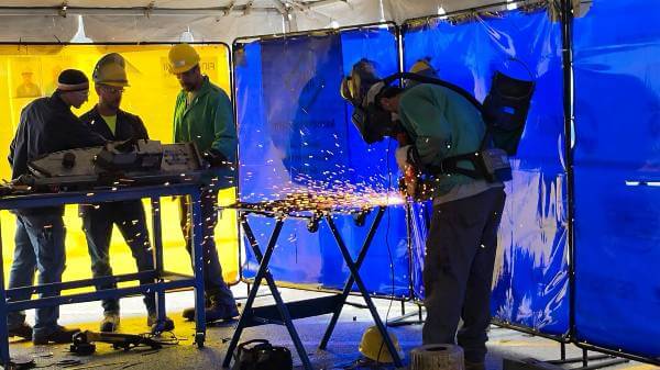 individuals working on welding projects, wearing safety gear