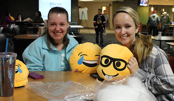 Students show off their emoji plushies in the cafeteria
