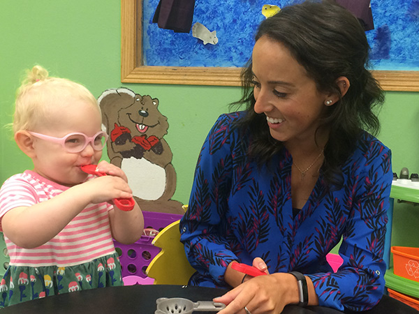 An early childhood education student works with a toddler