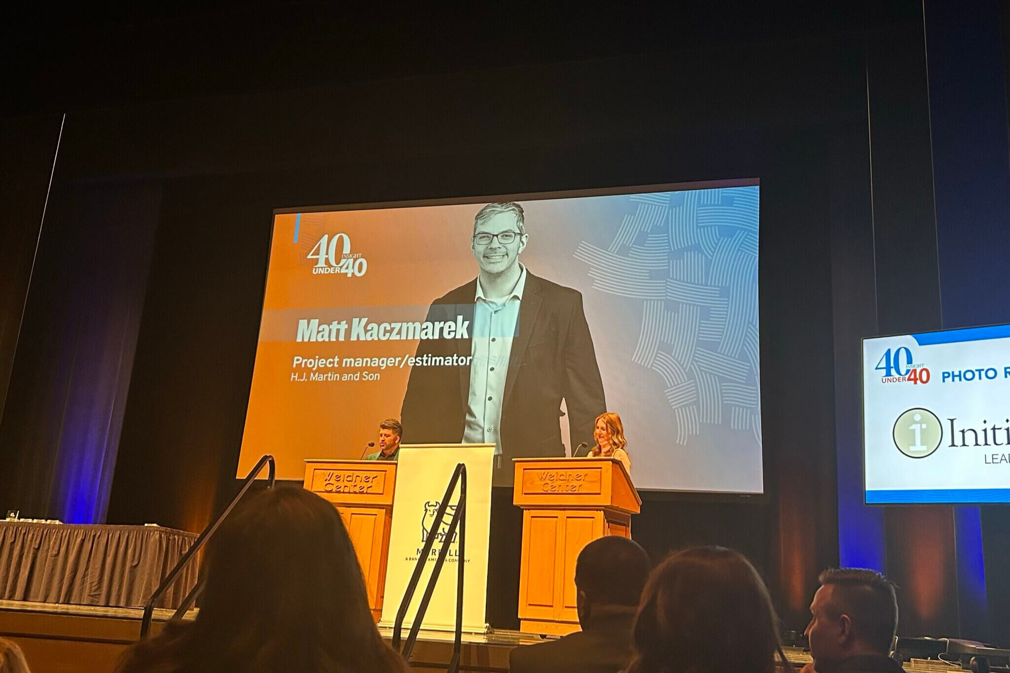 Matt Kaczmarek pictured on large screen during 40 Under 40 Award ceremony
