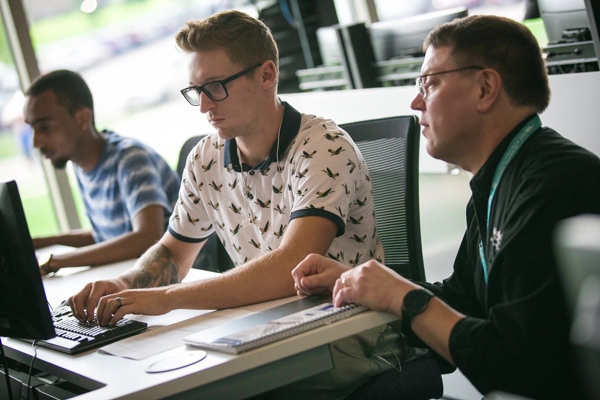 A student and advisor work together in front of a computer