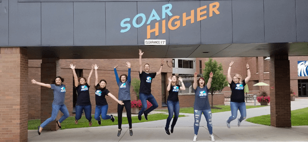 Recruiters jump beneath a welcome banner