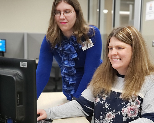 A staff members works with a student to get their test environment set up
