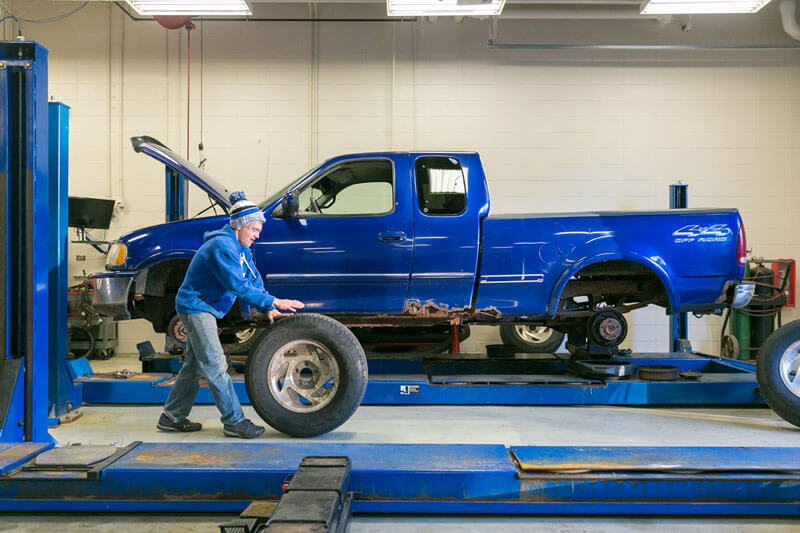 An automotive student works on a truck 