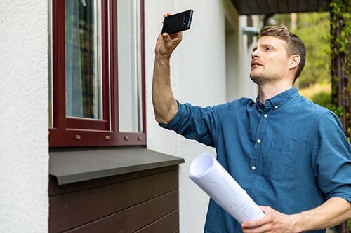 Man Taking Photos of Home with Phone Camera