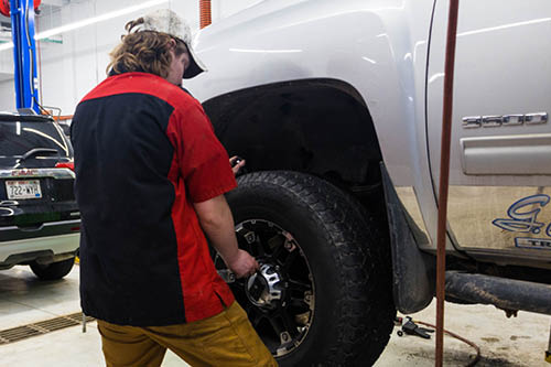 A high school student earns dual credit learning about automotive maintenance