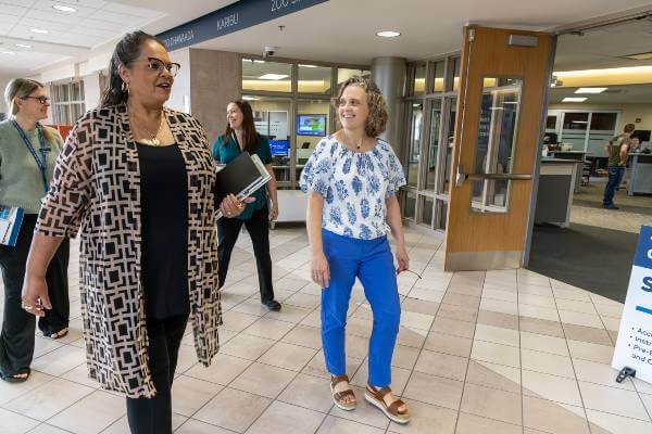 Jennifer Flatt walking through hallway with three staff members
