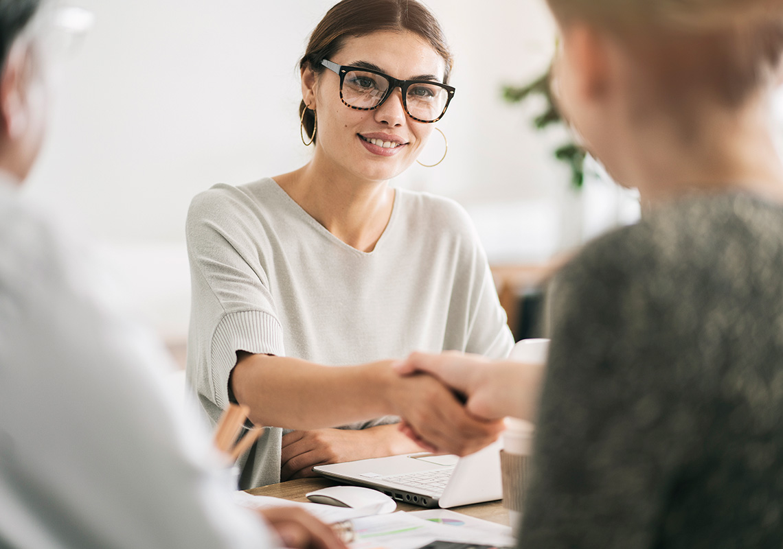 An employee shakes hands with their new employer