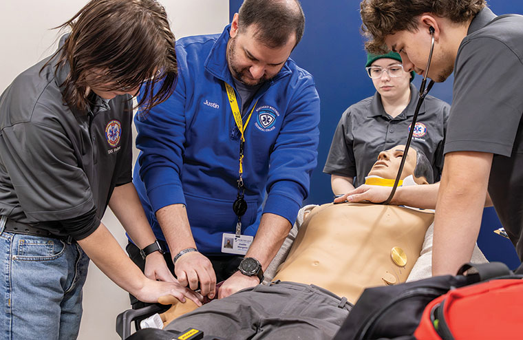 Instructor and students work on patient sim