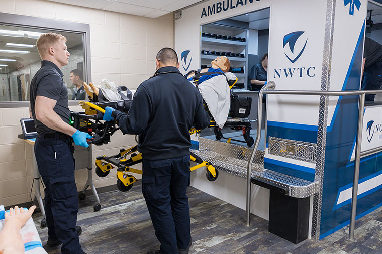 NWTC paramedic students load sim patient into ambulance