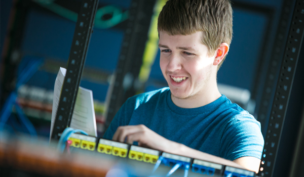 Male student working on computer hardware.
