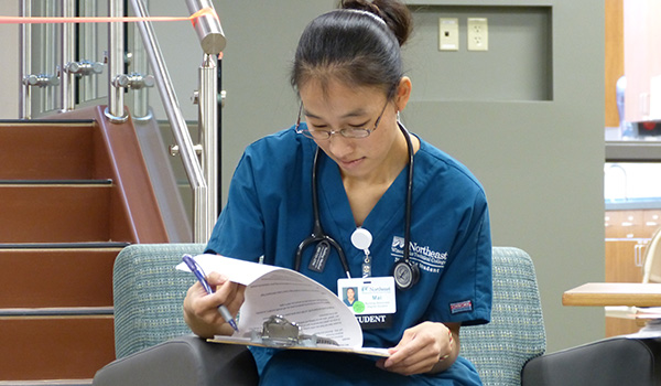 A nursing student reads through a checklist in the clinic