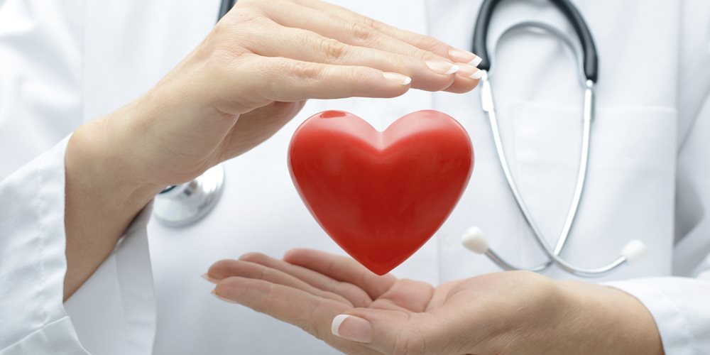 A nurse holds a heart symbol