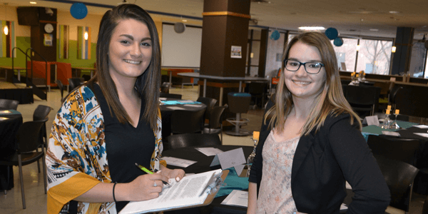 Two college of business students work in the commons