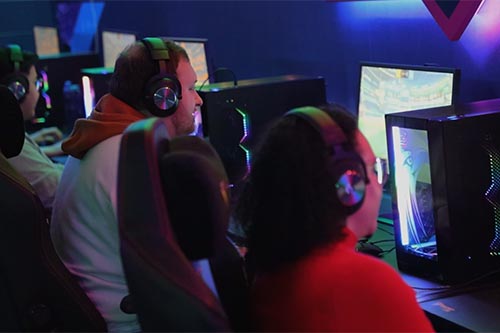 Gamers playing video games at computer monitors