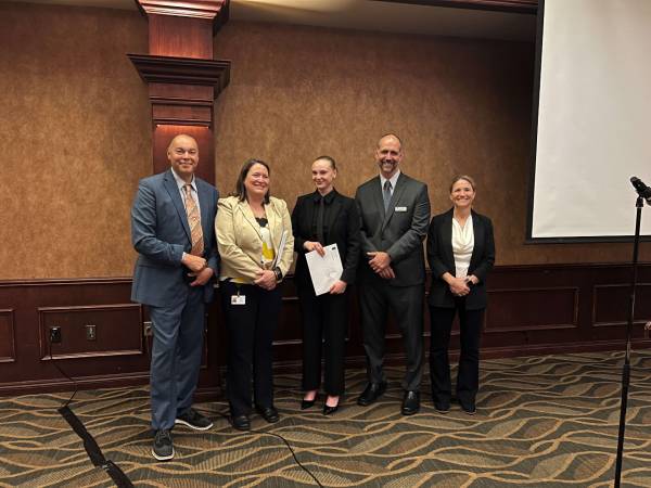Delilah Rose stands with NWTC faculty and staff at Law Enforcement Academy graduation