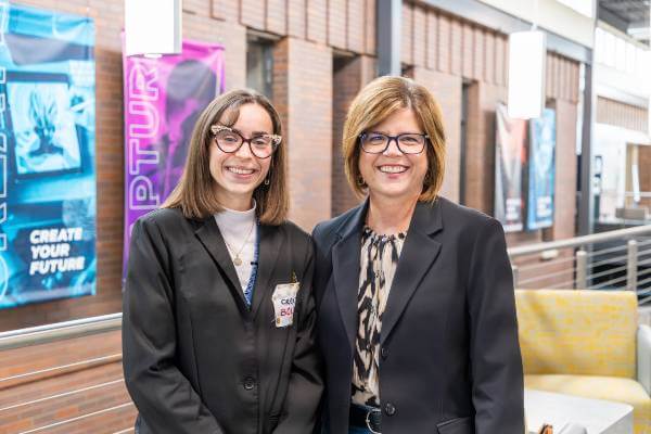 Amanda Miceli and Kristen Raney stand together, facing camera, smiling