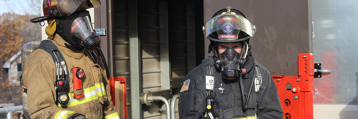 Firefighters outside of a burning building