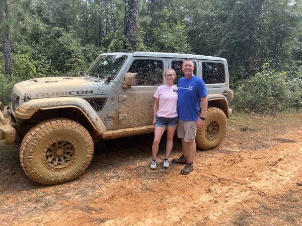 Rachel McIntosh and her husband standing by her Jeep