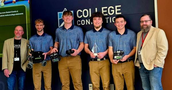 Kevin Grabian stands with group of students who competed in a robotics challenge