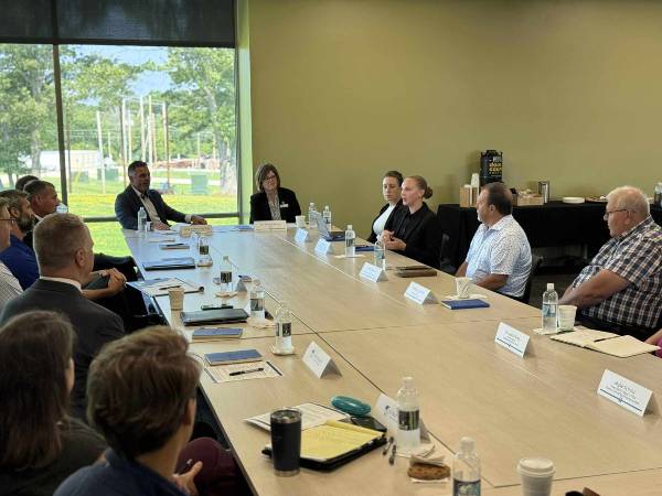 Delilah Rose sits at a table with Congressman Tony Wied, NWTC President Kristen Raney, and several local and college leaders