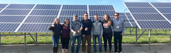 Energy and Conservation club members in front of a sloar panel
