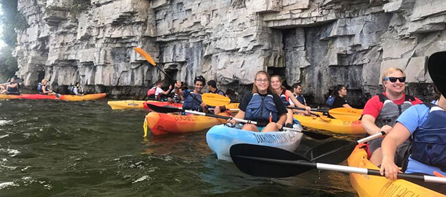 Students kayak together on a river