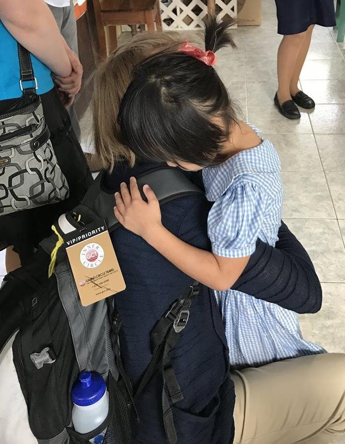Study abroad student hugs a local child