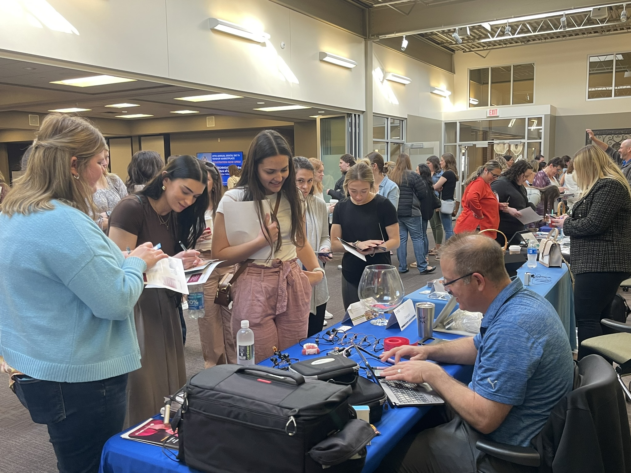 Conference Attendees talking with a vendor at Dental Day