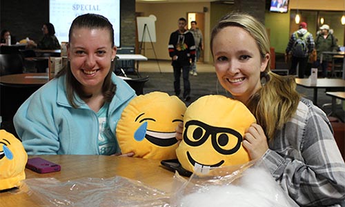 Students show off their emoji plushies in the cafeteria