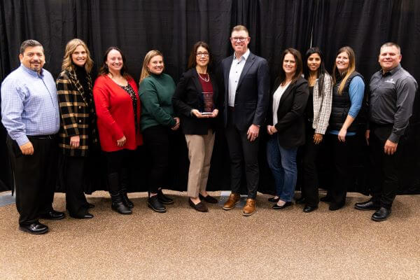 Green Bay Packaging employees stand with award, facing camera