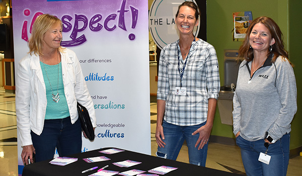 Staff members sign iRespect pledges at a booth in the commons