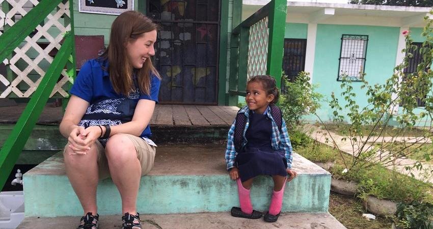 A study abroad student smiles at a local child