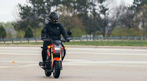 Student riding motorcycle on road