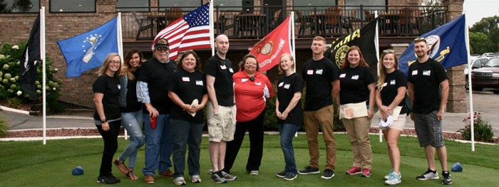 Student Veterans of America club members in front of flags