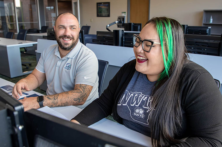 Students smile while working in a classroom